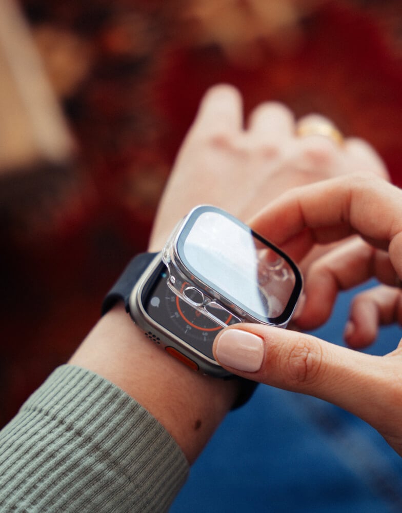 Person placing screen protector on Apple Watch