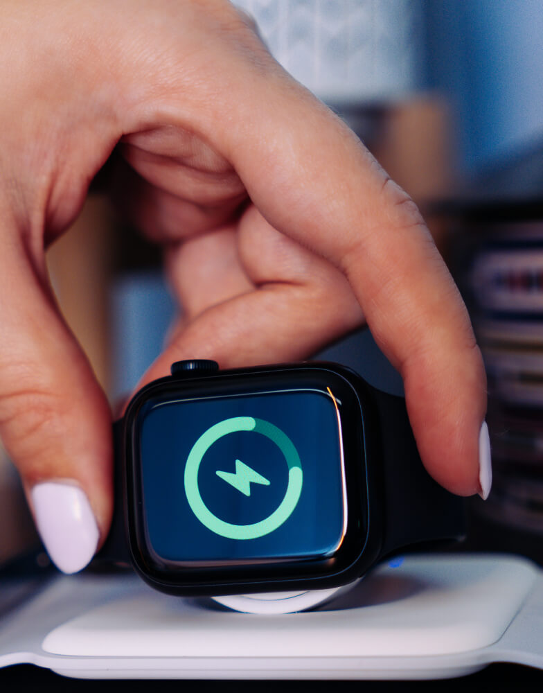 Person putting Apple Watch on charging dock