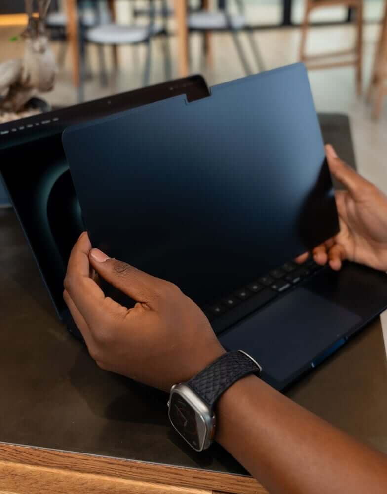Person putting screen protector on MacBook
