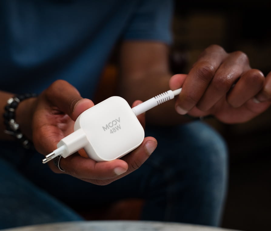 Person charging Apple Watch and iPhone on wireless charger