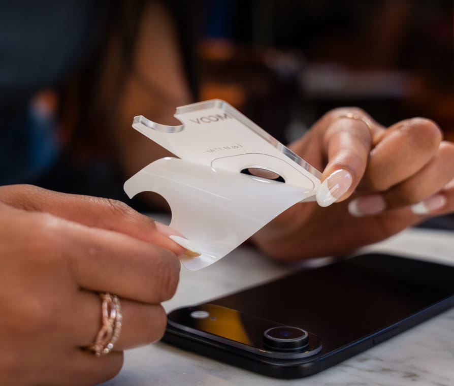 Person putting screen protector on iPhone