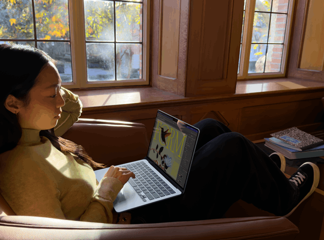 A person sitting in a chair using their MacBook Air