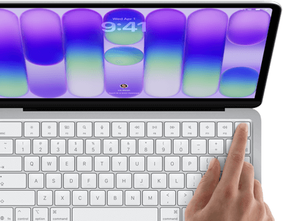MacBook Neo, silver colour, showing login screen, person's finger on Touch ID sensor in top-right corner of keyboard