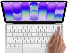 MacBook Neo, silver colour, showing login screen, person's finger on Touch ID sensor in top-right corner of keyboard
